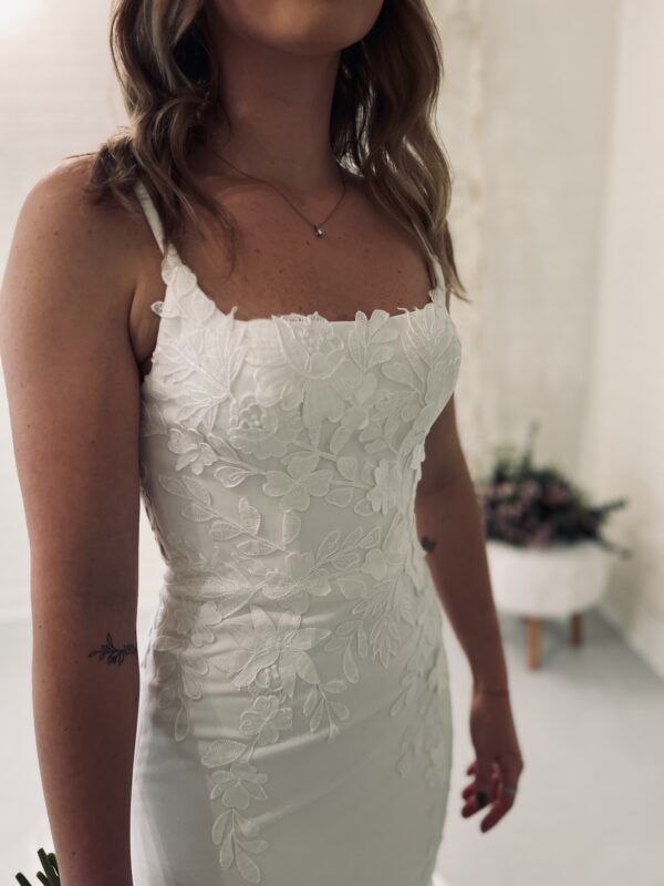 Lace wedding dress with square neckline on bride